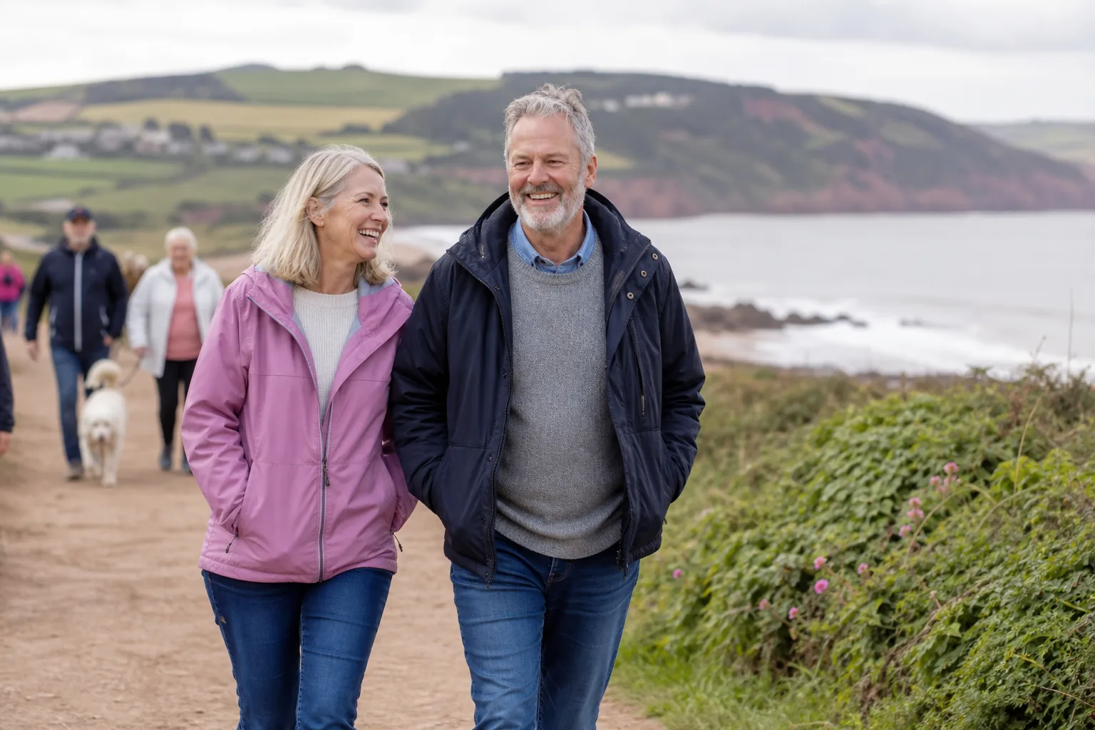 Two people talking beside a Devon harbour
