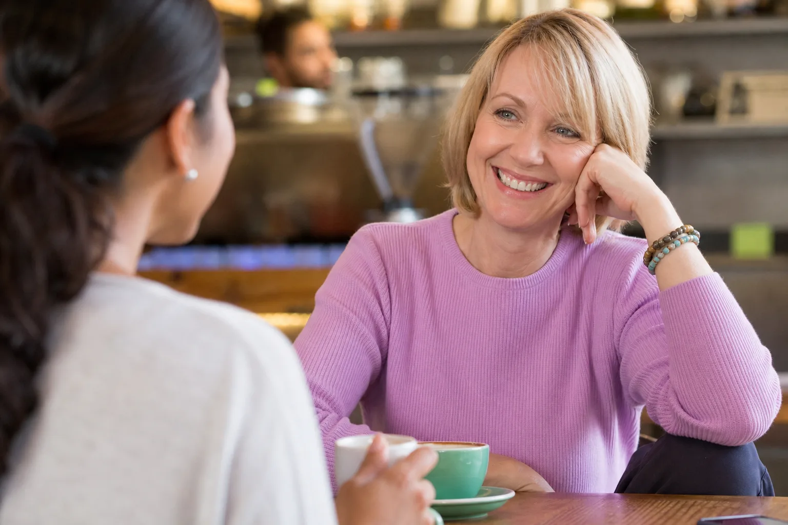 Woman enjoying a conversation with a man at a Devon café